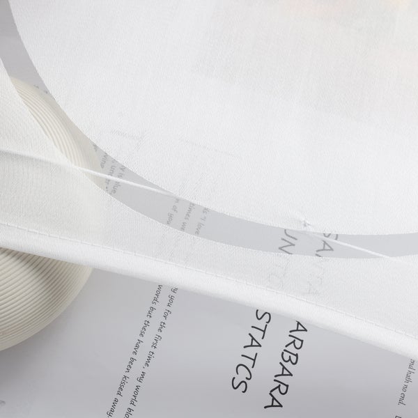 Detailaufnahme von einem weißen Vorhang mit aufgedruckten Texten.