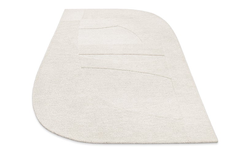 Hellbeiger Teppich mit unregelmäßiger Form und abstraktem geometrischem Muster in Hoch-Tief-Optik.