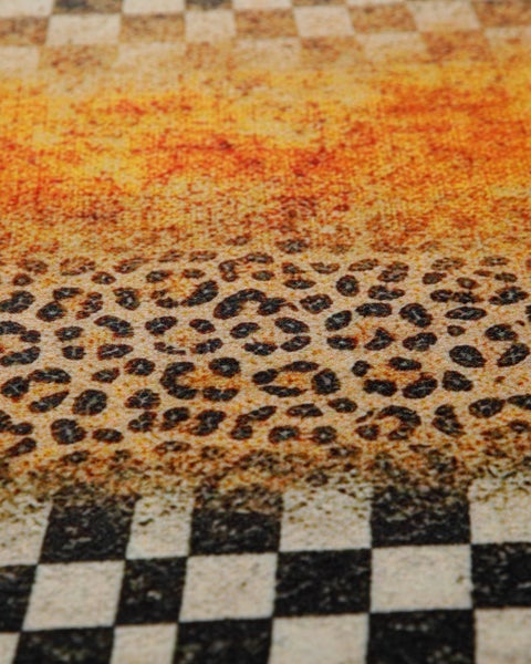 Nahaufnahme eines gemusterten Teppichs mit Leopardenprint und Karomuster.