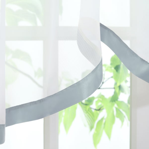 Dekoschals mit Zierstreifen vor Fenster