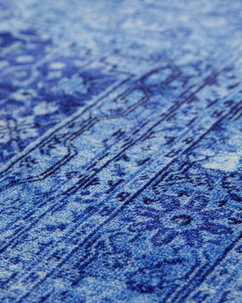 Nahaufnahme eines Kurzflorteppichs mit blauem Vintage-Muster.