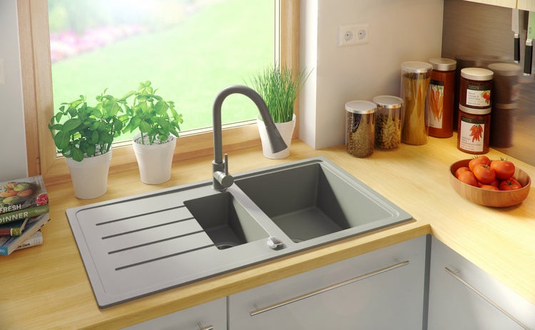 Küchenspüle mit Abtropffläche, Wasserhahn und dekorativen Elementen auf einer Küchentheke