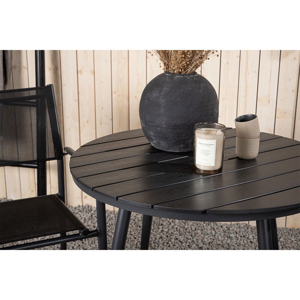 Gartentisch mit Dekoration wie Vase, Kerze und Tassen