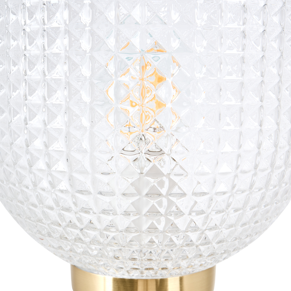 Detailaufnahme einer Tischleuchte mit einem kugelförmigen Lampenschirm aus strukturiertem Glas und einem Sockel