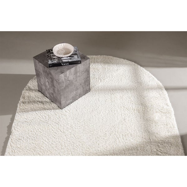 Ovaler Teppich mit hochflorigem Flor, kombiniert mit einem Beistelltisch und einem Stuhl