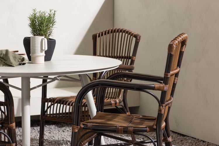 Gartentisch mit Rattanstühlen und Dekoration im Außenbereich