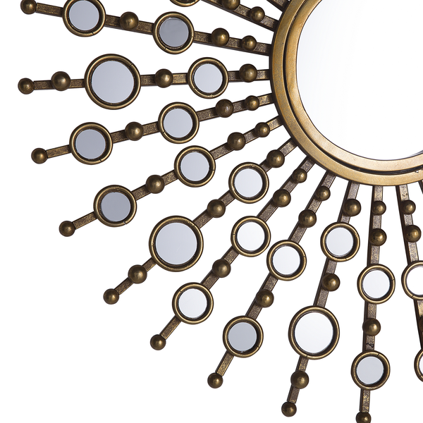 Dekorativer Wandspiegel in Sonnenform mit Kerzenständer und Tischdekoration auf einer Kommode