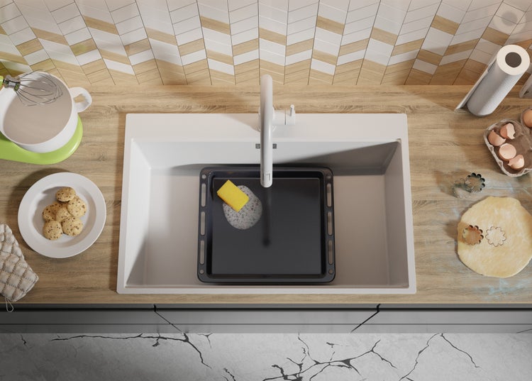 Küchenszene mit Spüle, Backblech, Spülmittel, Teig, Ausstecher und Zutaten auf einer Arbeitsfläche