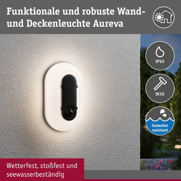 Ovale Außenwandleuchte Aureva mit Bewegungsmelder an einer Fassade, warm leuchtend. Symbole für IP65, IK10 und Seewasserbeständigkeit.