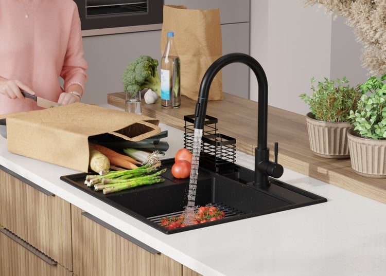 Küchenszene mit Spüle, Armatur, Gemüse und Person beim Kochen