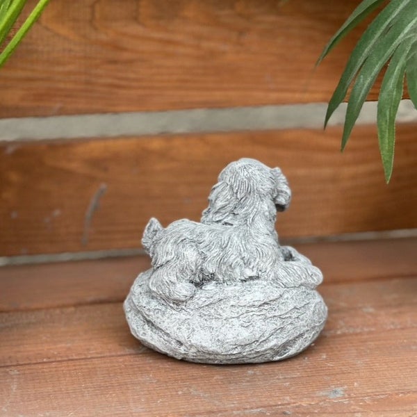 Dekorative Gartenfigur aus Stein in Form eines liegenden Hundes für den Außenbereich.