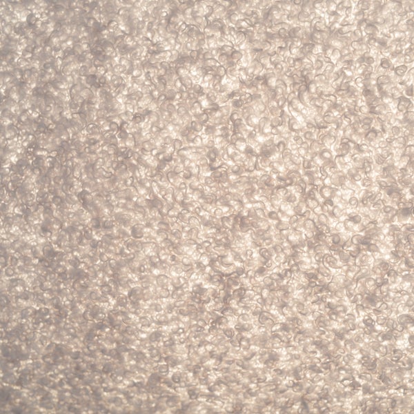 Dekorative Tischleuchte mit einem Bezug aus weichem Stoff auf einem Holztisch.