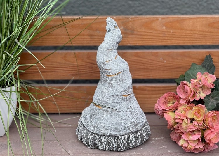 Gartenfigur in Form einer Zipfelmütze aus Beton oder Stein mit einer strukturierten Oberfläche.