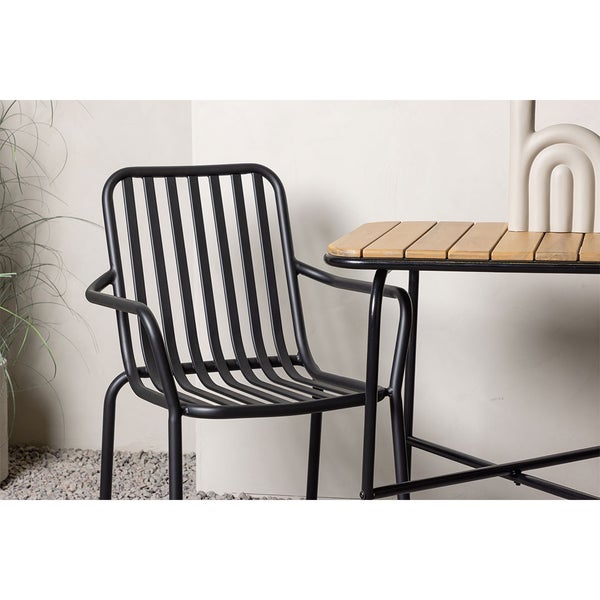 Schwarzer Metallstuhl mit Armlehnen an Holztisch