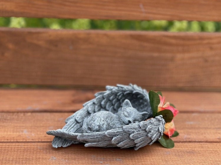 Grabschmuck in Form einer schlafenden Katze mit Engelsflügeln aus Stein mit künstlicher Blume als wetterfeste Dekoration für den Garten