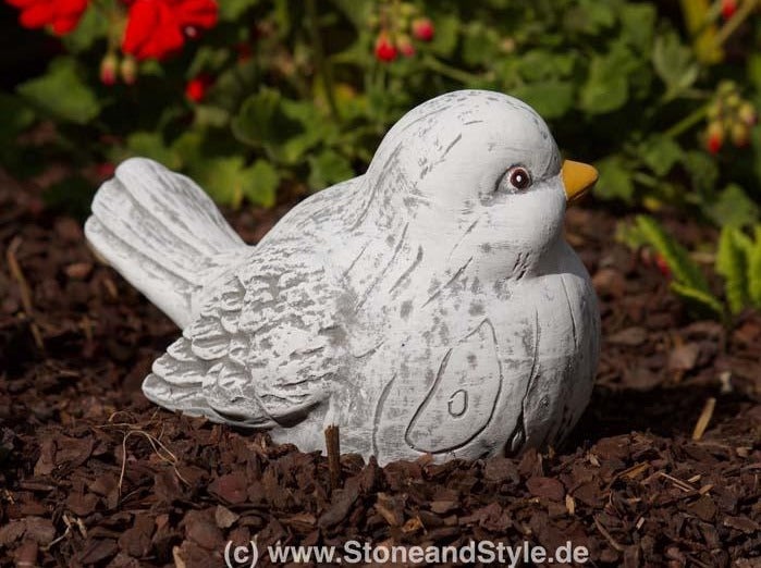 Dekorative Vogel Gartenfigur aus Stein für den Außenbereich platziert auf Rindenmulch