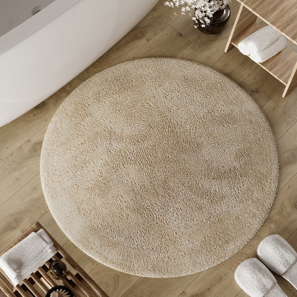 Runder Hochflor-Teppich in Beige, weiche Struktur.