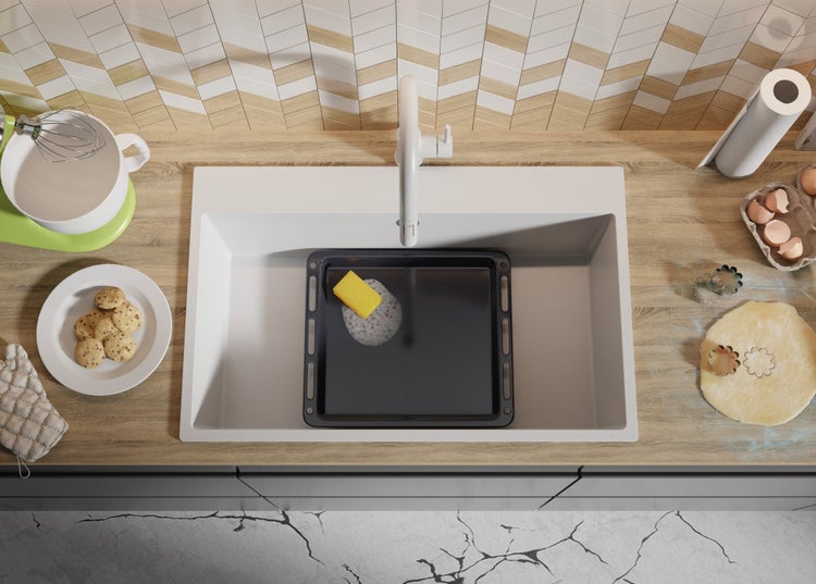 Küchenszene mit Spüle, Armatur, Backblech, Schwamm und Backutensilien auf einer Arbeitsplatte