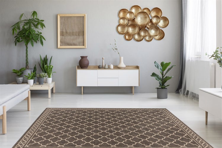 Modernes Wohnzimmer mit braunem Teppich mit geometrischem Muster, weißem Sideboard, Zimmerpflanzen und goldener Wanddekoration.