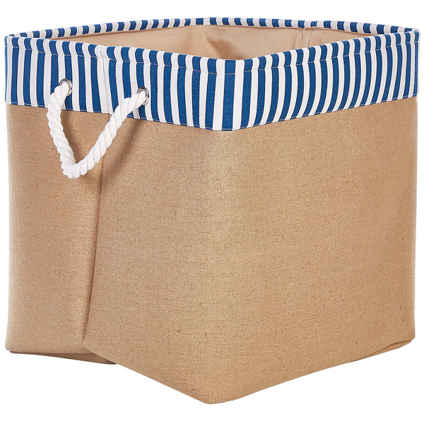 Kleiner Hund in rundem geflochtenem Hundebett mit Plüschfutter in modernem Wohnzimmer mit Holzkommode, Sessel und Juteteppich.