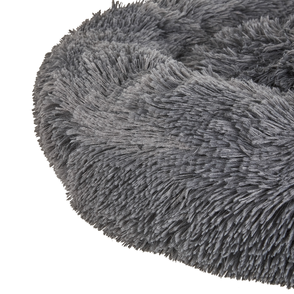 Detailansicht eines flauschigen grauen runden Haustierbetts aus langfloriger Plüschfaser.