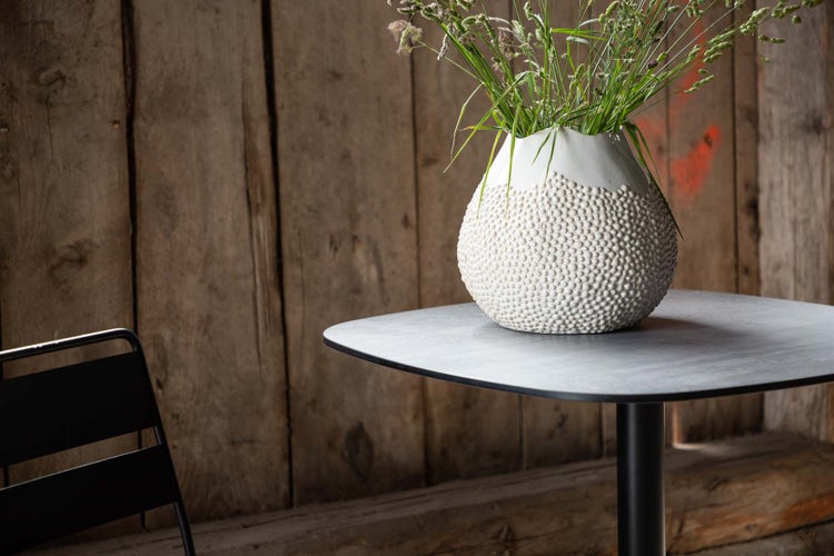 Dekorative Vase mit Pflanzen auf einem Tisch