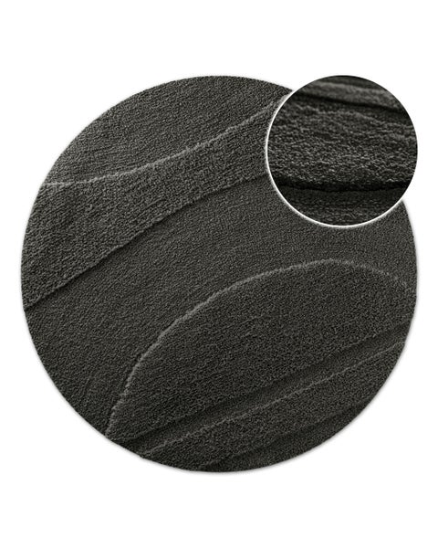 Runder, dunkelgrauer Teppich mit strukturierter Wellenoberfläche und Detailansicht der weichen Florstruktur.