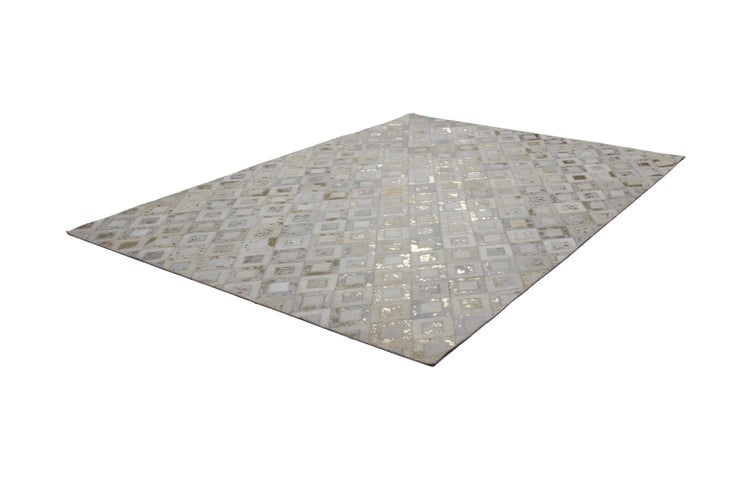 Rechteckiger Patchwork-Teppich aus Lederquadraten mit geometrischem Muster und metallisch goldenen Akzenten.