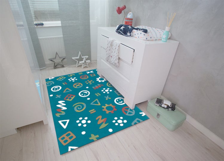 Bunter Kinderteppich mit Mustern in einem hellen Kinderzimmer mit weißer Kommode auf hellem Boden.