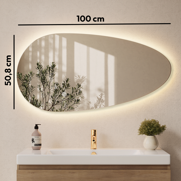 Organisch geformter Badezimmerspiegel mit LED Beleuchtung, Maße 100 mal 50,8 Zentimeter, montiert über einem Waschtisch mit Armatur.