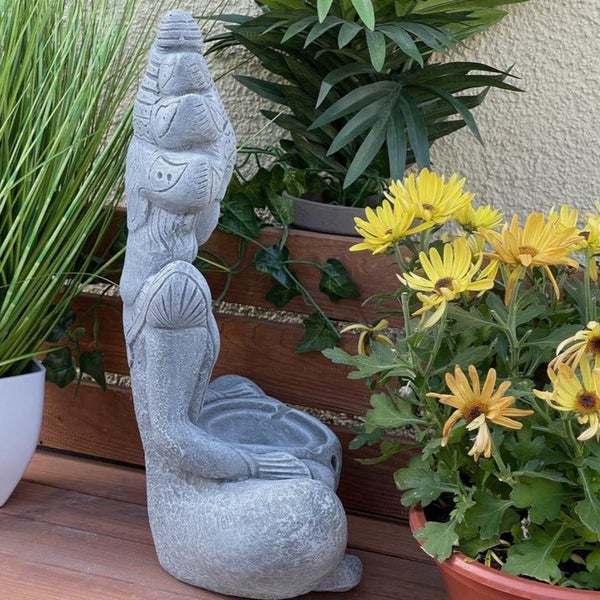 Steinfigur in Form einer sitzenden Frau als Pflanzgefäß für den Garten