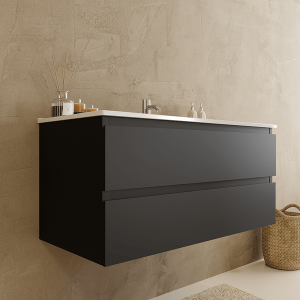 Moderner, wandhängender Waschbeckenunterschrank in Dunkelgrau mit zwei Auszügen und weißem Waschtisch in einem hellen, minimalistischen Badezimmer.