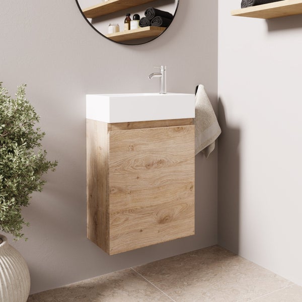 Wandhängender Waschtischunterschrank mit Keramikwaschbecken in Holzoptik inklusive Wasserhahn in einem modernen Badezimmer.