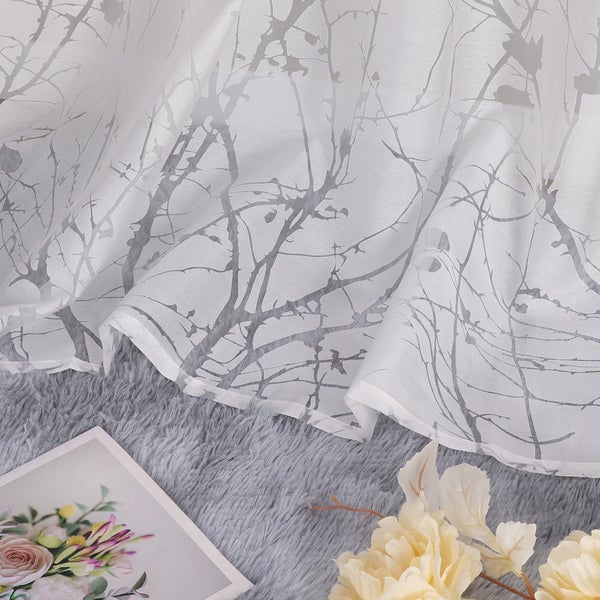 Weißes, transparentes Gardinenmaterial mit filigranem Zweigmuster.