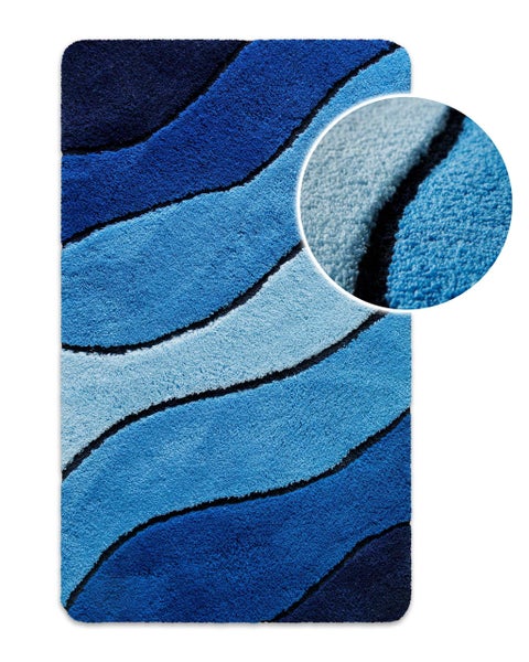 Blauer Badteppich mit Wellenmuster und Detailansicht der weichen Textur