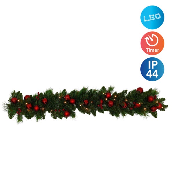 Festliche Tannengirlande mit LED-Beleuchtung und roten Kugeln