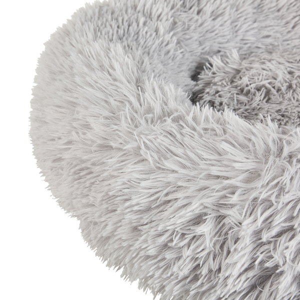 Rundes, flauschiges Hundebett aus grauem Langhaar-Plüsch.