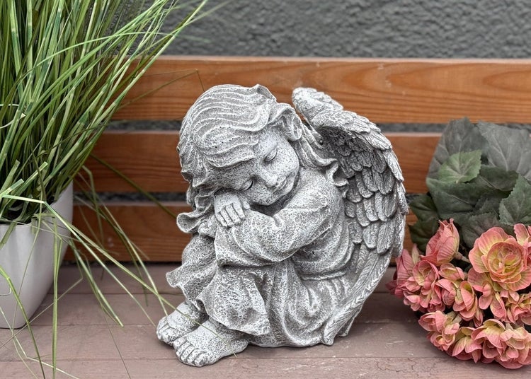 Schlafende Engelsfigur aus Steinguss, geeignet als Gartendekoration oder Grabschmuck.