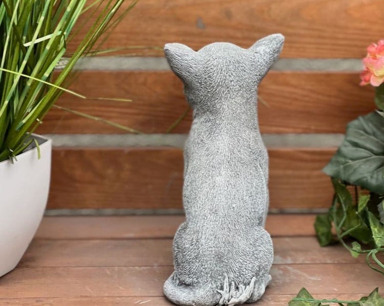 Gartenfigur sitzender Hund von hinten in grauem Steinguss, dekorative Tierfigur für den Garten.