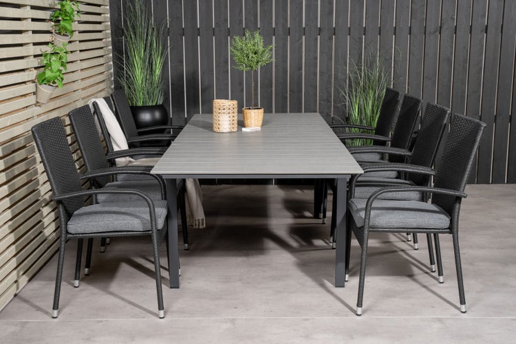 Gartenszene mit Esstisch, Flechtstühlen und Dekoration