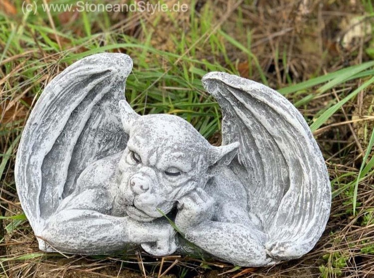 Dekorative Gartenfigur in Form eines liegenden Wasserspeiers aus Steinguss für den Außenbereich.