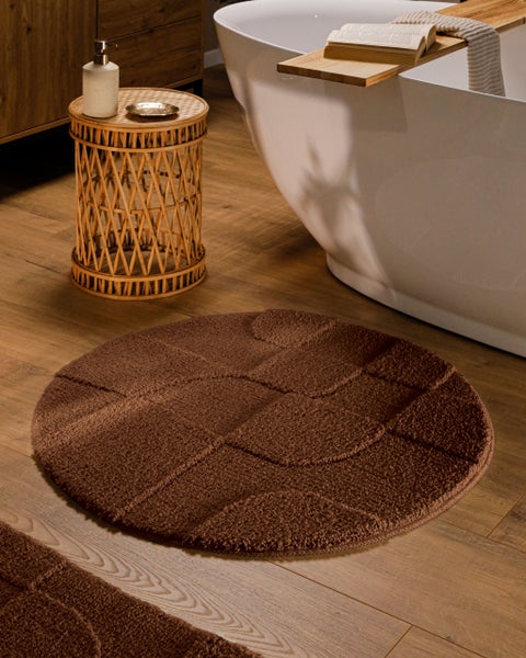 Runder brauner Badeteppich mit geometrischem Hoch-Tief-Muster aus weichem Material, Detailansicht der Struktur.