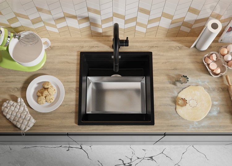 Küchenspüle mit Armatur, Teig, Ausstecher, Mixer, Plätzchen und Eiern auf einer Küchentheke