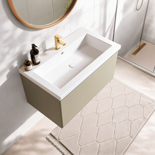 Modernes Badezimmer mit Waschtisch, wandhängendem Unterschrank, goldfarbener Armatur, rundem Spiegel und gemustertem Badteppich.