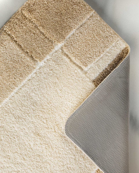 Badematte mit quadratischem Muster, weichem Hochflor und rutschhemmender Unterseite.