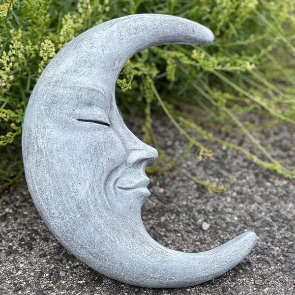 Gartenfigur in Form einer Halbmondsichel mit Gesichtszügen aus Stein