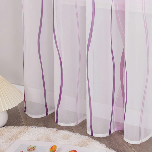 Transparente Gardine mit violetten Wellenstreifen in einem hellen Zimmer neben einer Lampe und einem weißen Teppich.