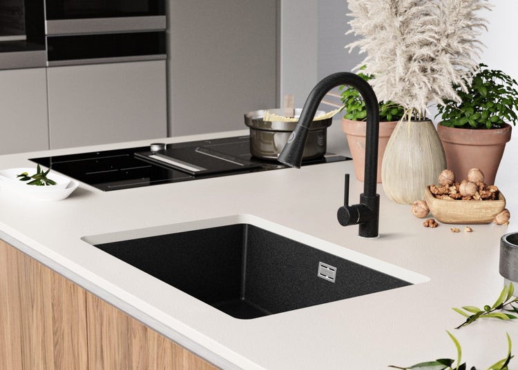 Küchenszene mit Spüle, Armatur, Kochfeld und Dekoration