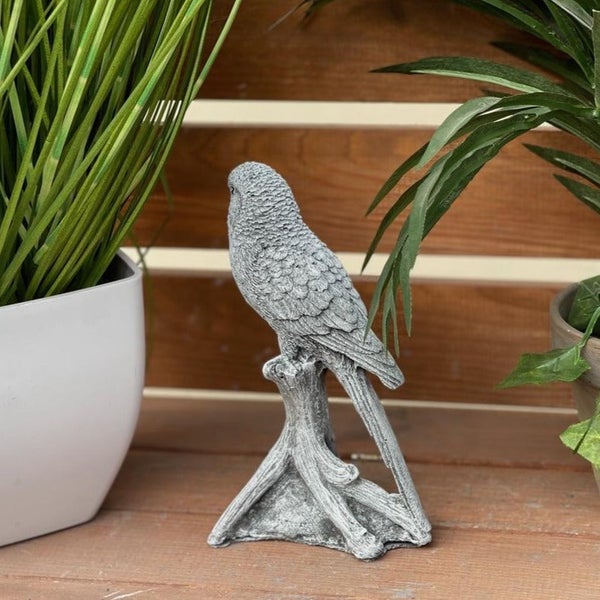 Dekorative Gartenfigur eines Wellensittichs aus Steinoptik sitzend auf einem Ast für den Außenbereich.