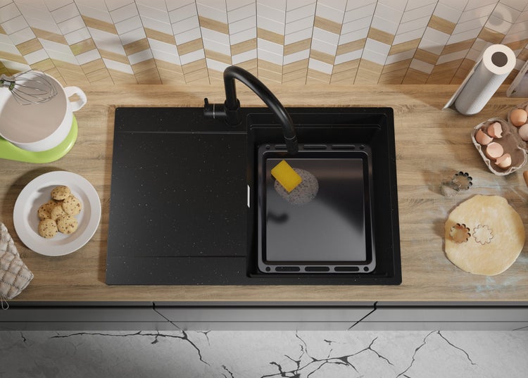 Küchenspüle mit Armatur und Küchenutensilien auf einer Arbeitsplatte